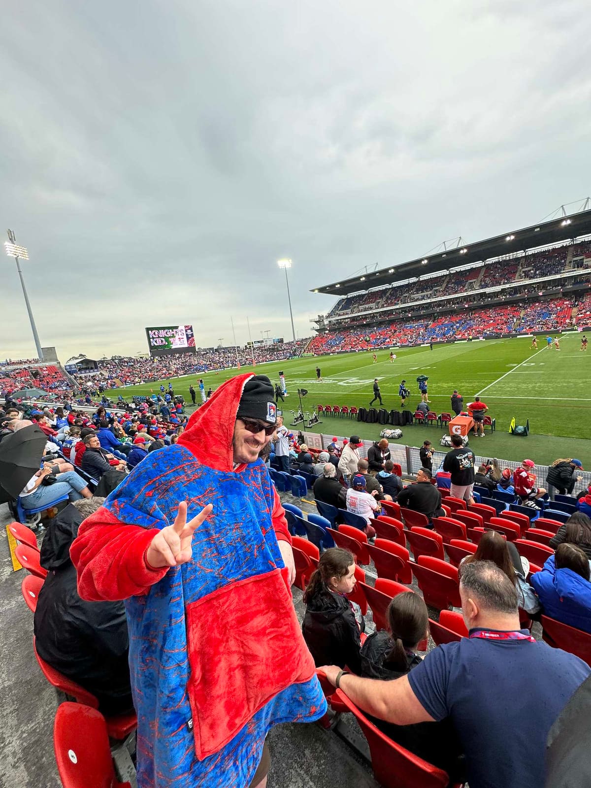 A member of the teen group wrapped in a Newcastle Knights blanket in the stands at McDonald Jones Stadium