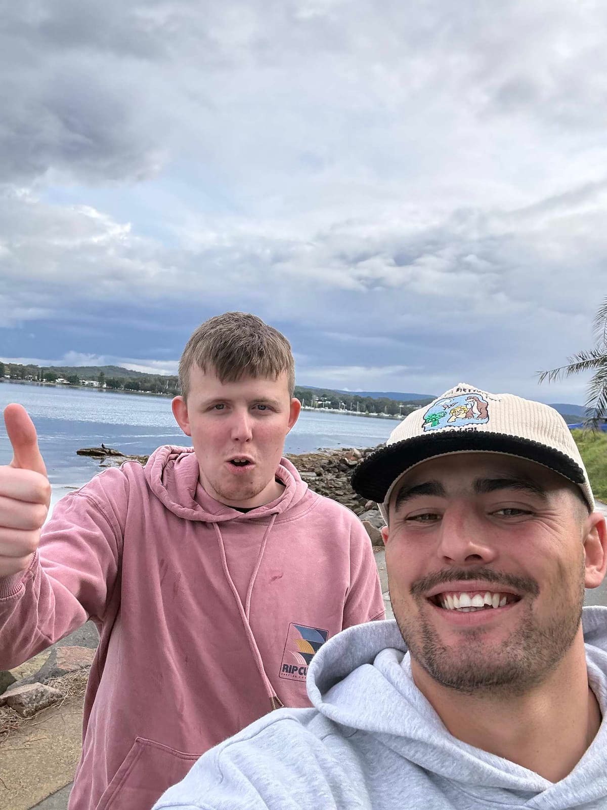A Pal Supports worker and the young man he supports on the shore of Lake Macquarie