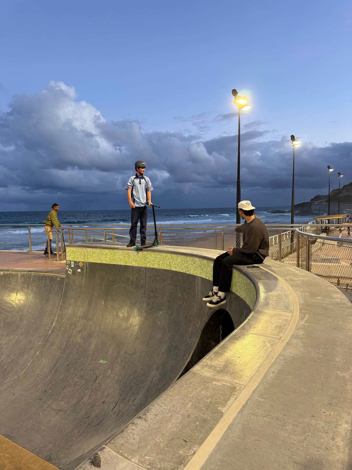 A teenager on a scooter at a coastal skate park near Newcastle in the evening light